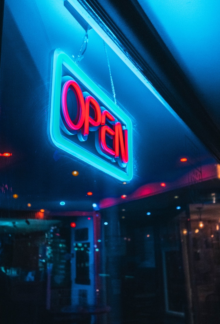 A storefront is illuminated by an open sign.