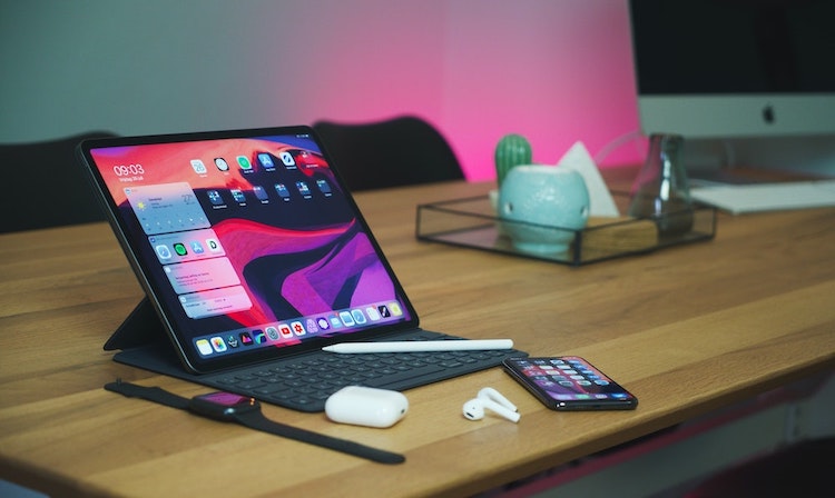Multiple Apple devices sit on a desk