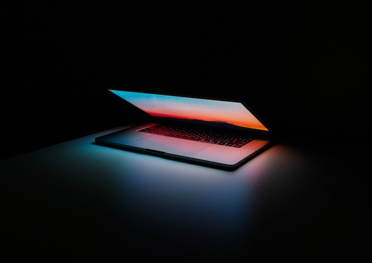 A MacBook Pro glows at night