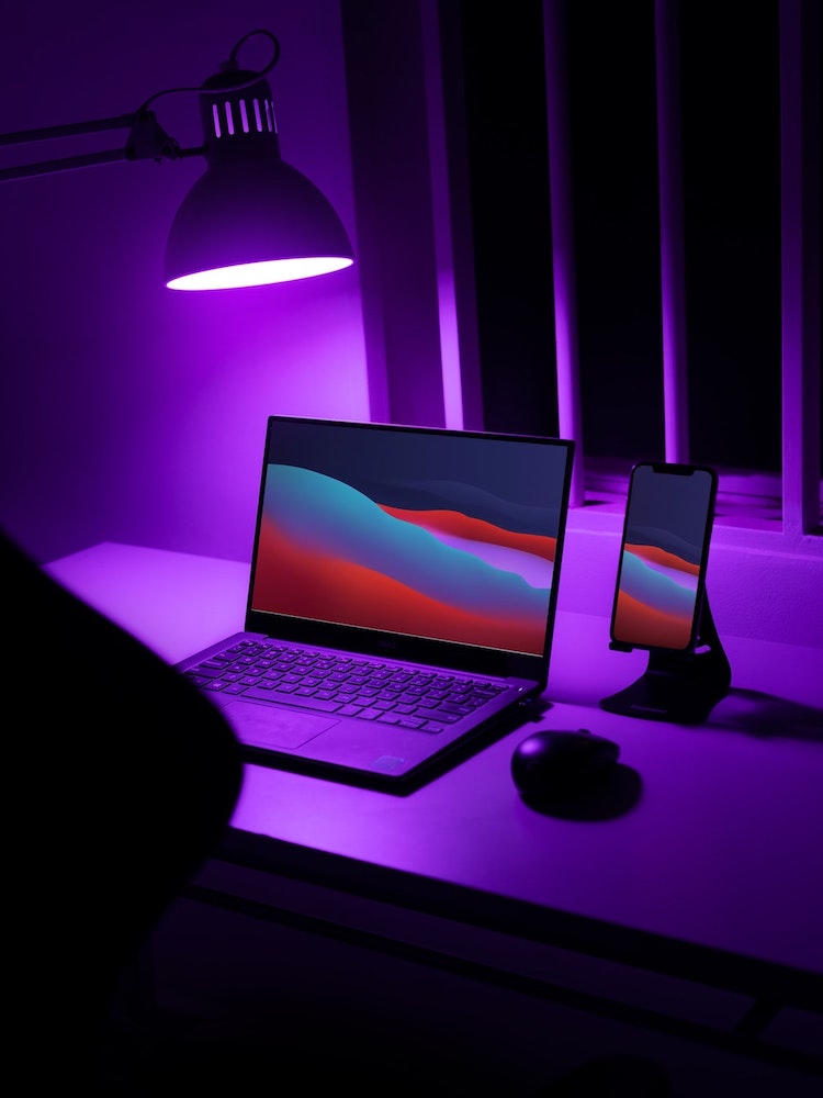 A laptop and phone glow at night