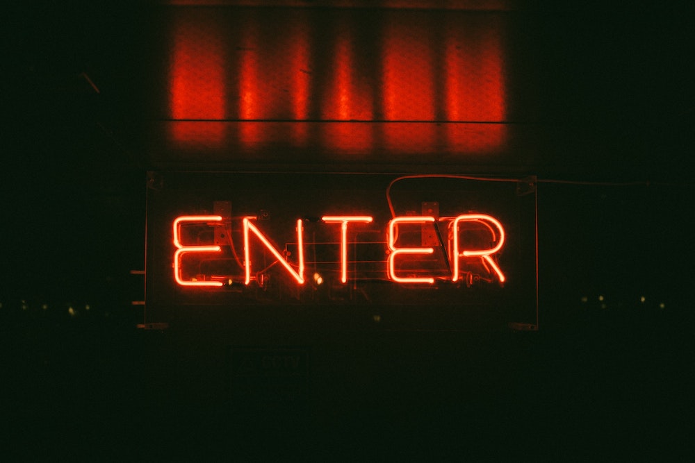 A glowing neon enter sign